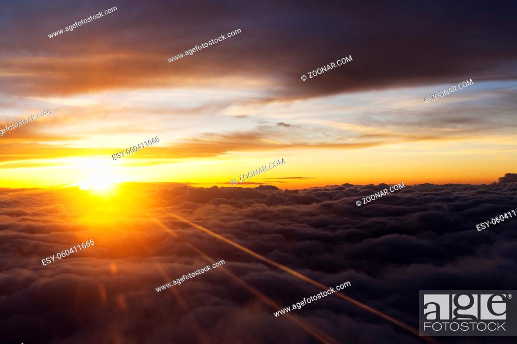 Stock Photo: Sunrise over fluffy clouds with bright rays of light.