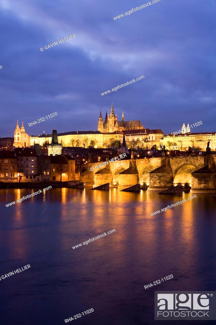 Stock Photo: St. Vitus Cathedral, Charles Bridge and the Castle District illuminated at night in winter, seen from across the Vltava River, Prague, Czech Republic, Europe.