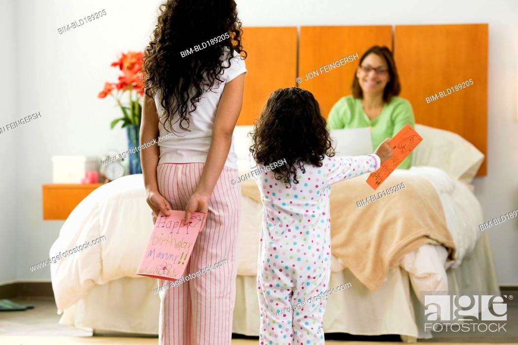 Stock Photo: Hispanic sisters with birthday card for mother.
