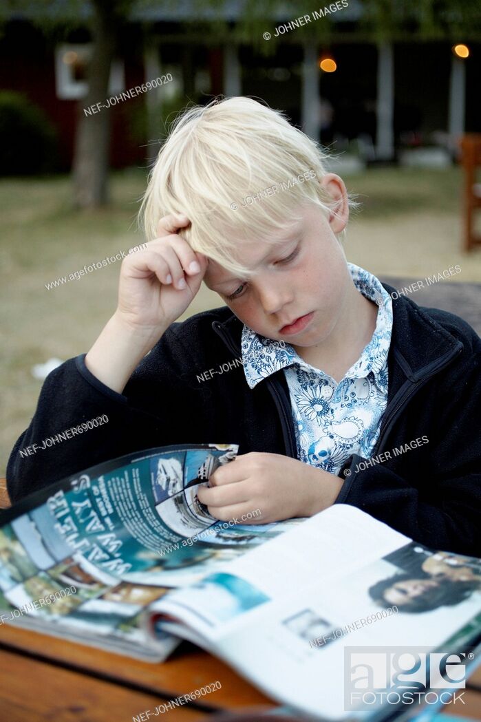 Imagen: Scandinavian boy reading a magazine, Sweden.