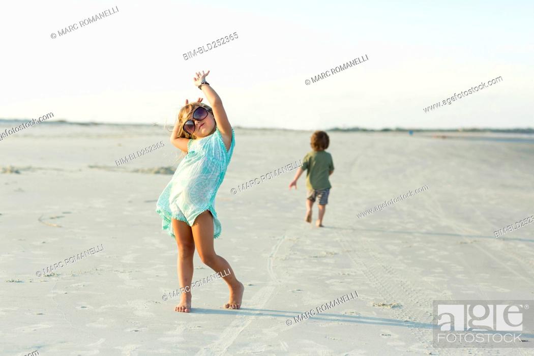 Stock Photo: Caucasian girl posing with sunglasses on beach.