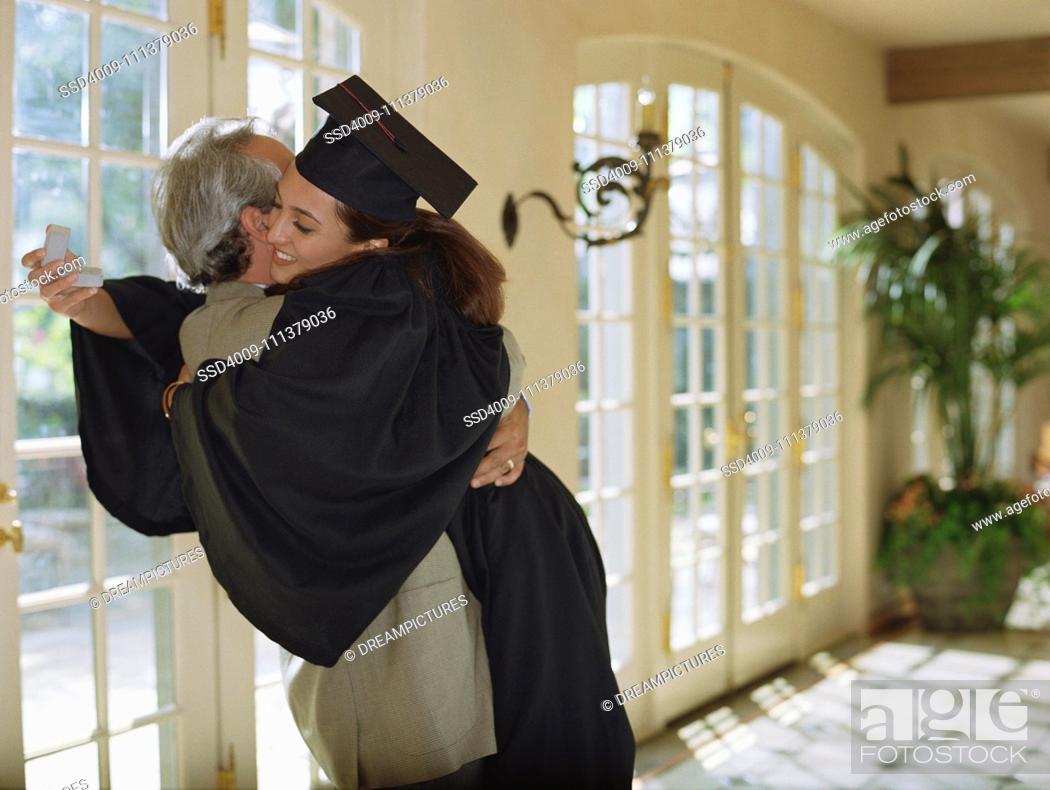 Stock Photo: Father giving daughter graduation gift.