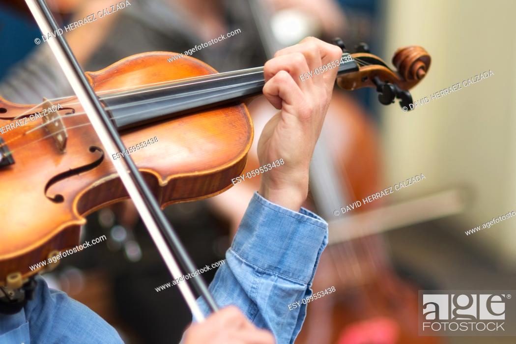 Stock Photo: Street musician playing violin in the streets .