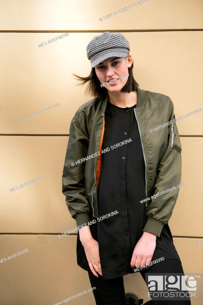 Stock Photo: Portrait of a stylish young woman at a wall.