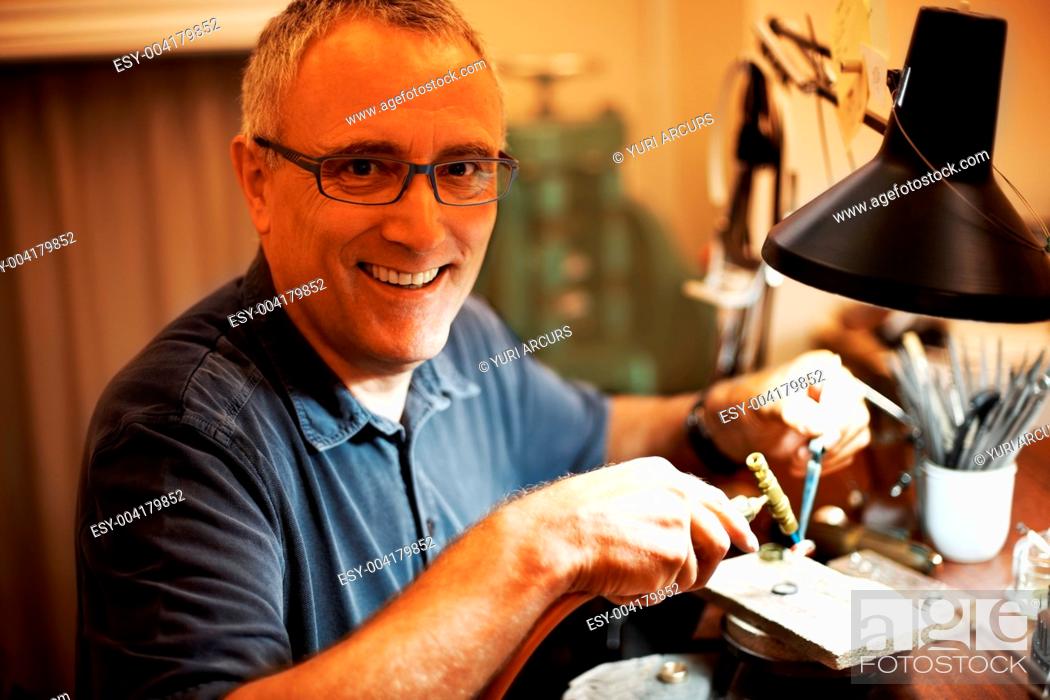 Photo de stock: Happy metalworker smiling while using a blowtorch.