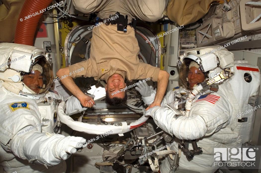 Stock Photo: European Space Agency (ESA) astronaut Paolo Nespoli (center), STS-120 mission specialist, turns a flip for astronauts Scott Parazynski (right).