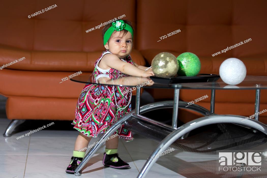 Stock Photo: Girl playing with colorful balls in a living room.