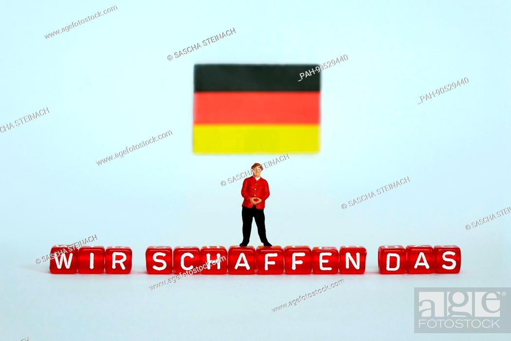 Stock Photo: ILLUSTRATION - A small figurine of German Chancellor Angela Merkel stands under a German flag and on top of letter-dice spelling out ""WIR SCHAFFEN DAS"" (WE.
