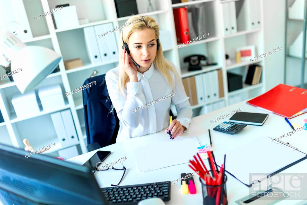 Stock Photo: A slender young girl in a white blouse is working in the office. The girl has white long hair. photo with depth of field.