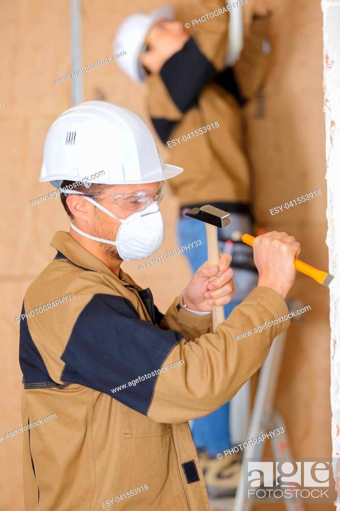 Stock Photo: Workman using hammer and chisel.