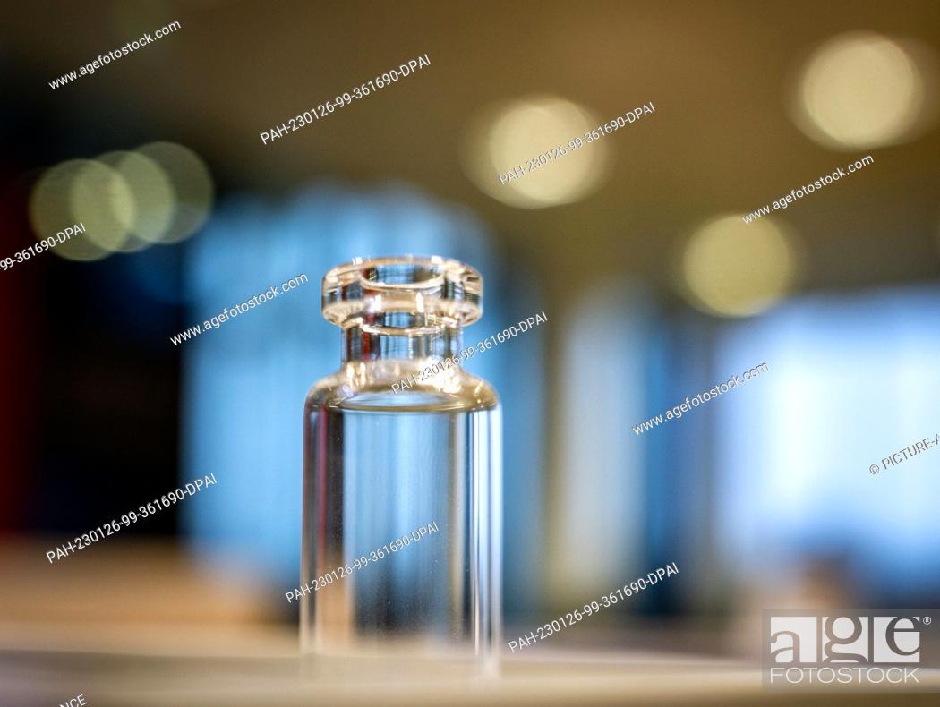 Stock Photo: PRODUCTION - 25 January 2023, Rhineland-Palatinate, Mainz: A glass vial, such as those used for filling vaccines, stands on a table at the company headquarters.