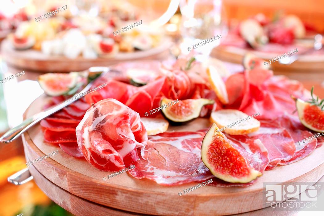Stock Photo: Italian antipasti and appetizers. board with slices prosciutto, salami, dried pork, salami ham with herbs. bread croutons.