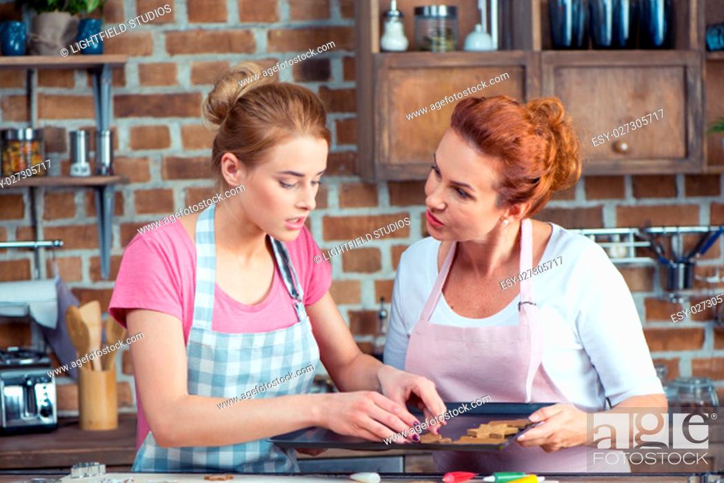 Stock Photo: Mother and her teenage daughter making Christmas cookies in kitchen.