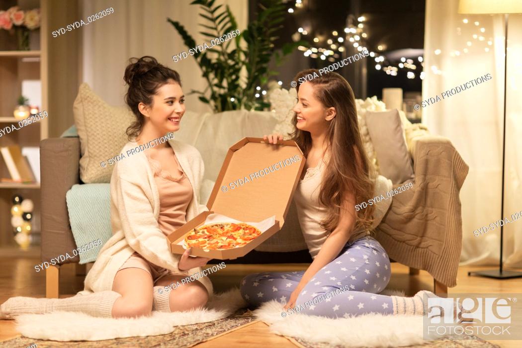 Stock Photo: happy female friends with pizza at home.
