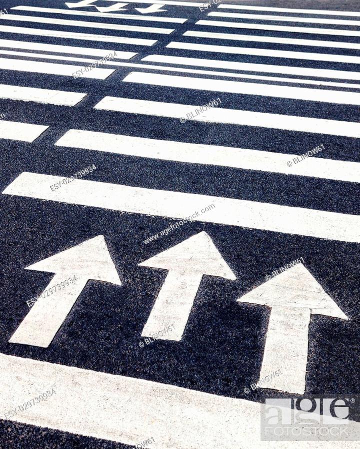 Stock Photo: Zebra crossing with white marking lines and direction of motion on asphalt.