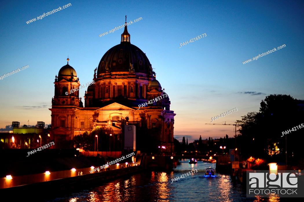 Stock Photo: The illuminated Berlin Cathedral and a tour ship are pictured from the Town Hall Bridge above the Spree river in the evening of 24 August 2013 in Berlin.