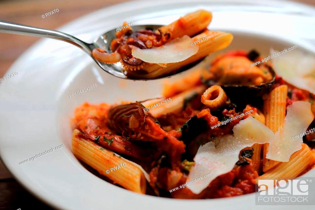 Stock Photo: Penne pasta tomato sauce arabiata with seafood on wood background vintage style.
