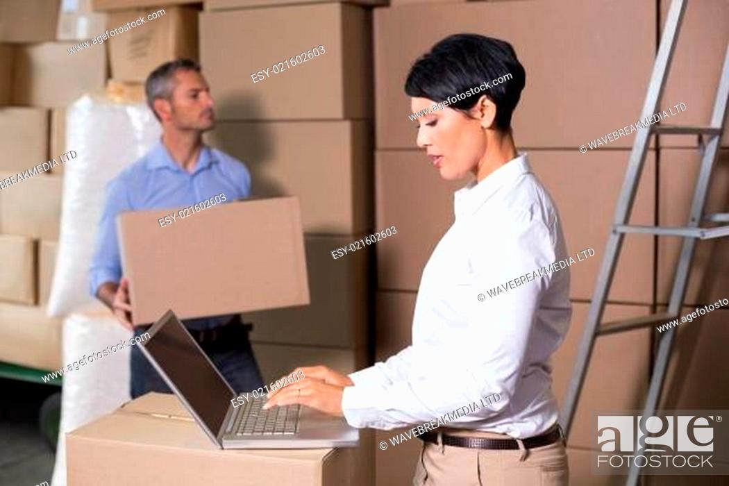 Stock Photo: Pretty warehouse manager using laptop.