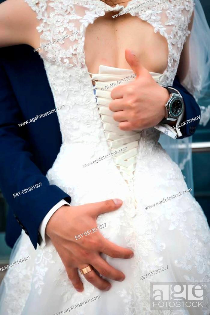 Stock Photo: Groom showing a gesture of his thumb up. as he is and in love with his bride and very happy. Concept of the right choise in love.