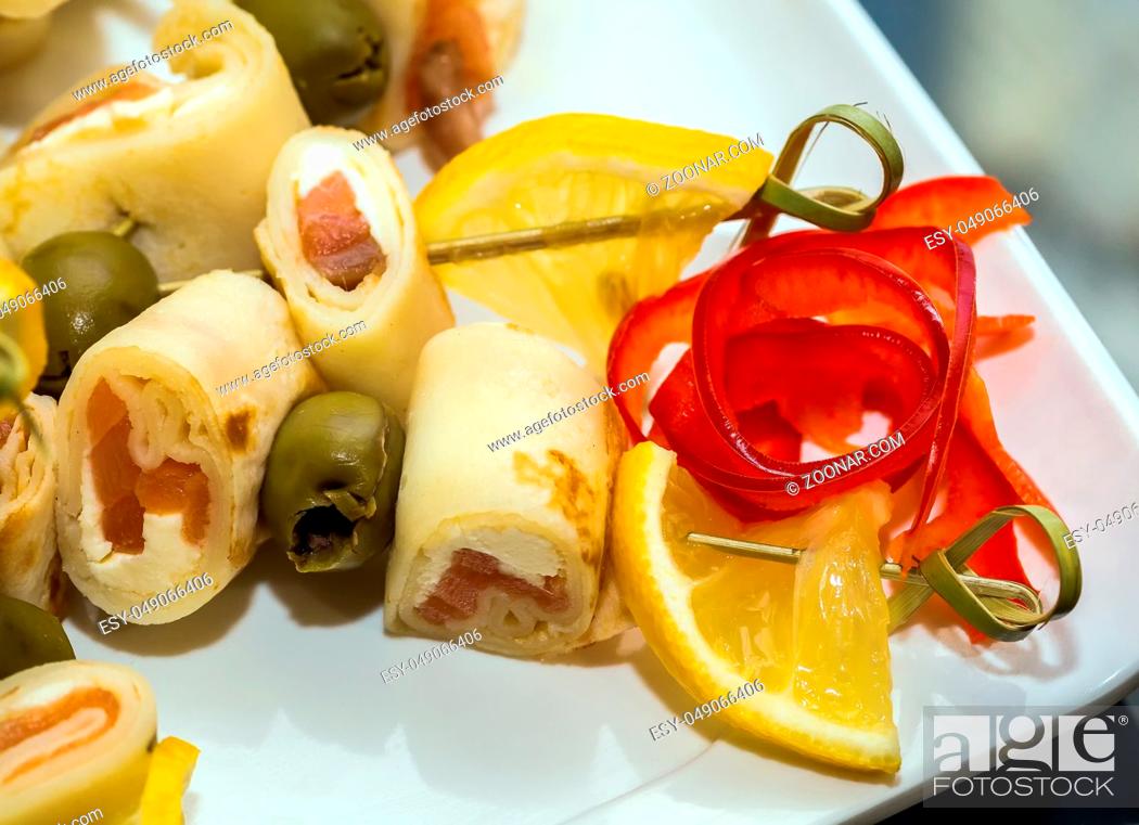 Stock Photo: close-up snacks assorted of canapes with fish roll and olives.