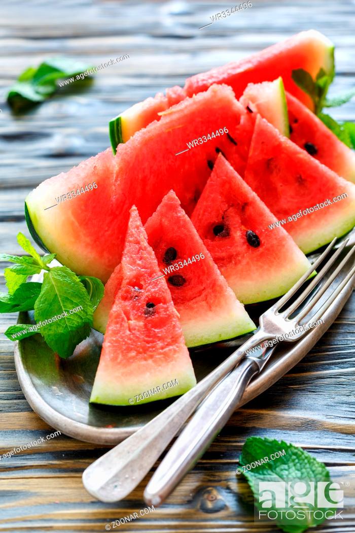 Stock Photo: Tray with slices of sweet watermelon and cutlery on a wooden table.