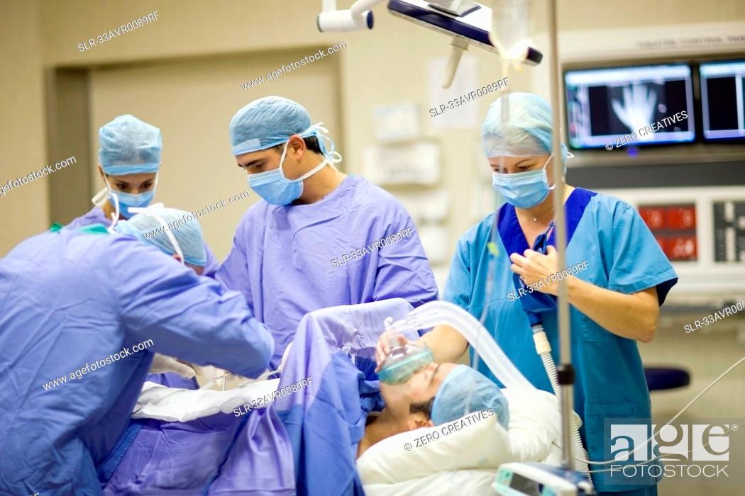 Stock Photo: Doctor and nurses performing operation.
