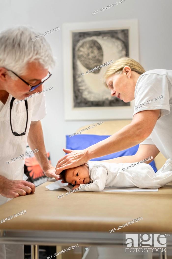 Stock Photo: Doctors examining baby.