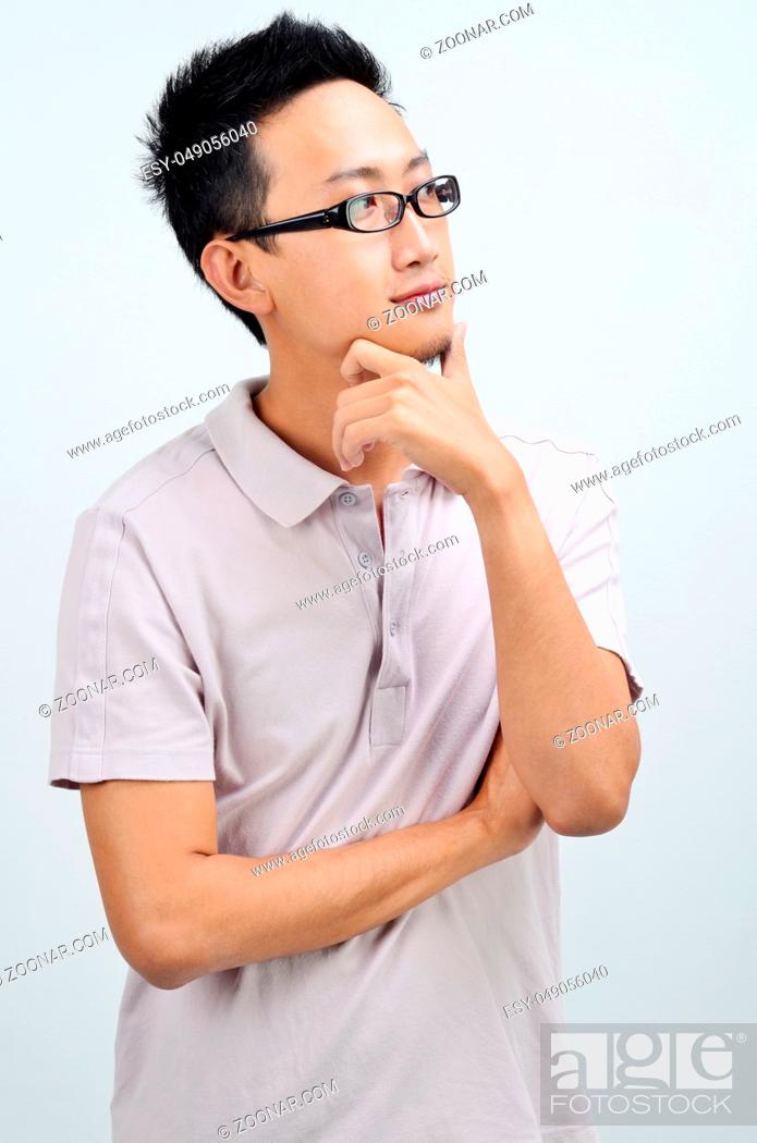 Stock Photo: Portrait of Asian man arms crossed looking at side, standing isolated on plain background.