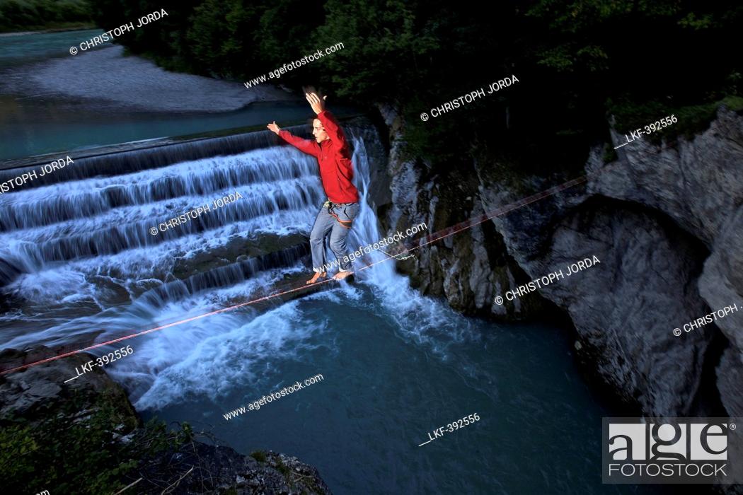 Stock Photo: Young man balancing on a highline over a stream, Fuessen, Bavaria, Germany, Europe.