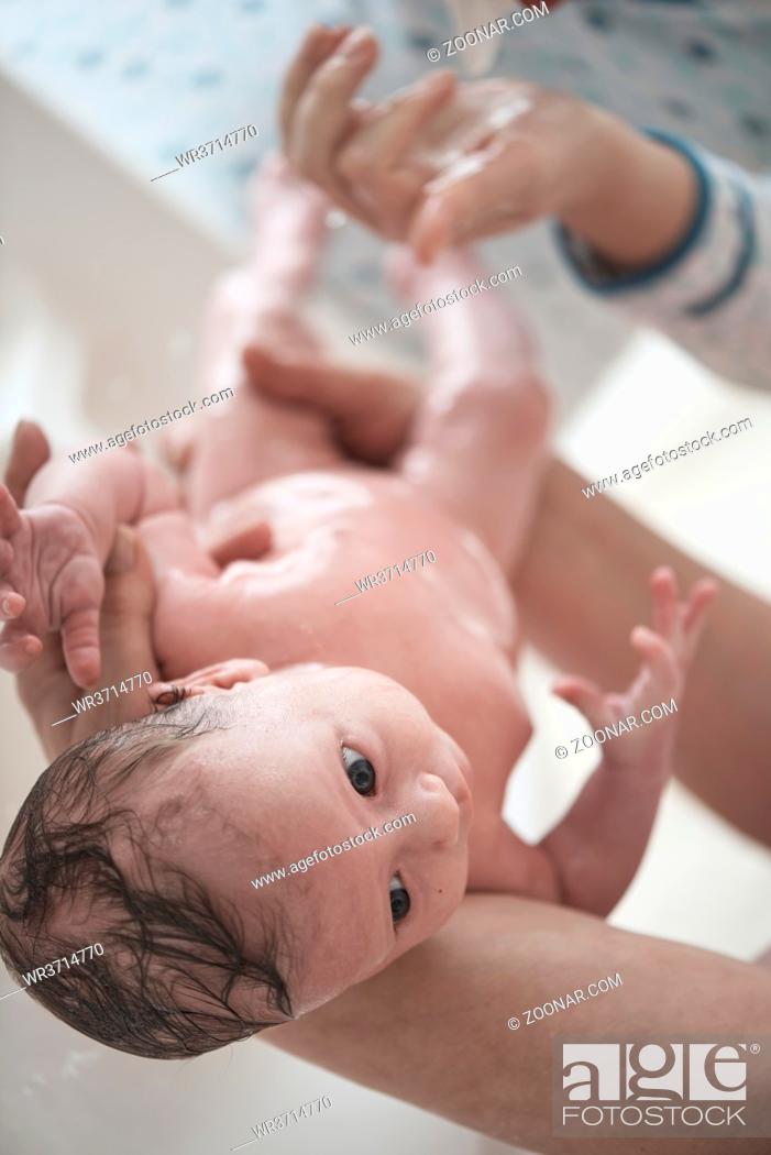 Stock Photo: Mother is bathing Newborn baby girl taking a bath.