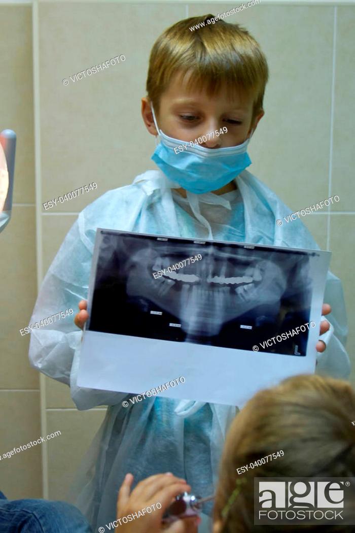 Stock Photo: child plays in a dentist. Choosing a profession.