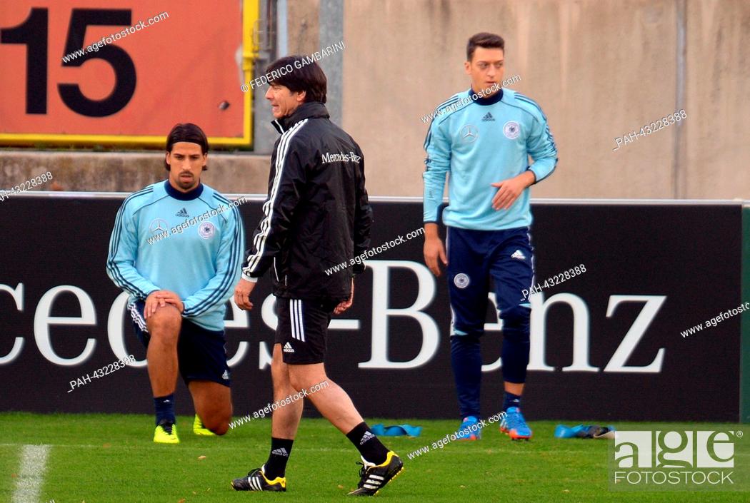 Stock Photo: Germany's head coach Joachim Loew (M) walks past Sami Khedira (back-L) and Mesut Oezil during the training session of the German national soccer team in.