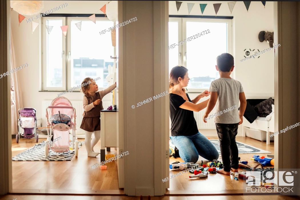 Stock Photo: Mother and kids cleaning house.