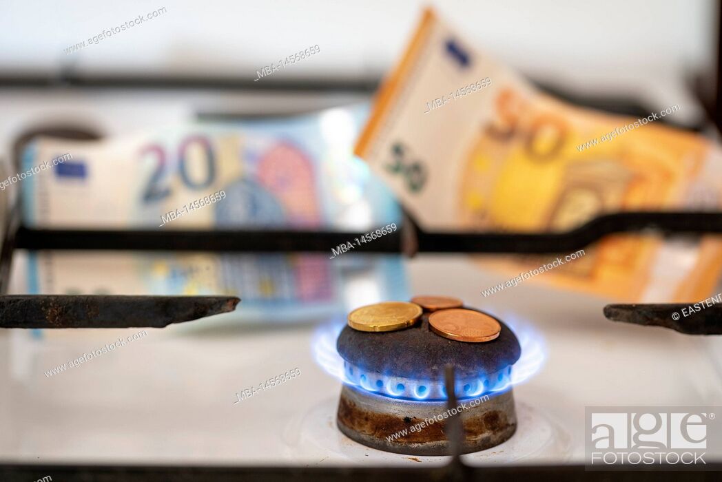 Stock Photo: Gas stove hob, gas flame, small change, banknotes behind it.