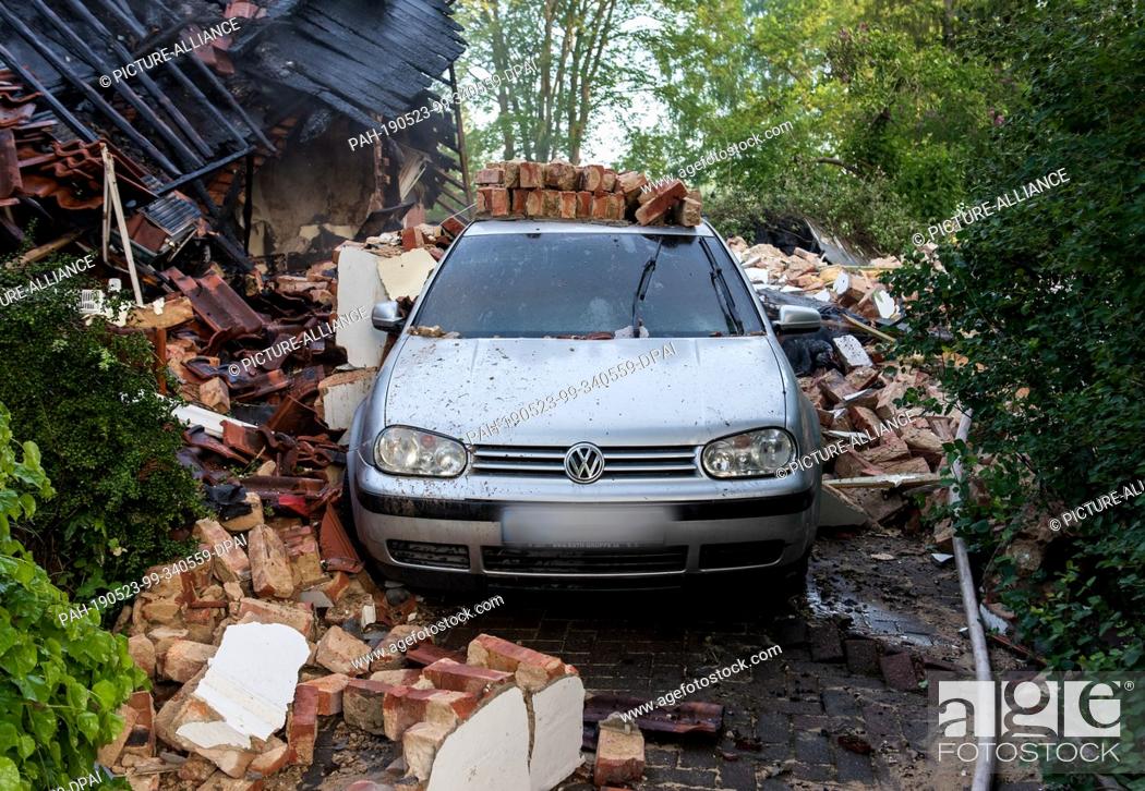 Stock Photo: 23 May 2019, Schleswig-Holstein, Wohltorf: A car is standing in the ruins of a house that was destroyed in a fire. The fire department was still looking for.