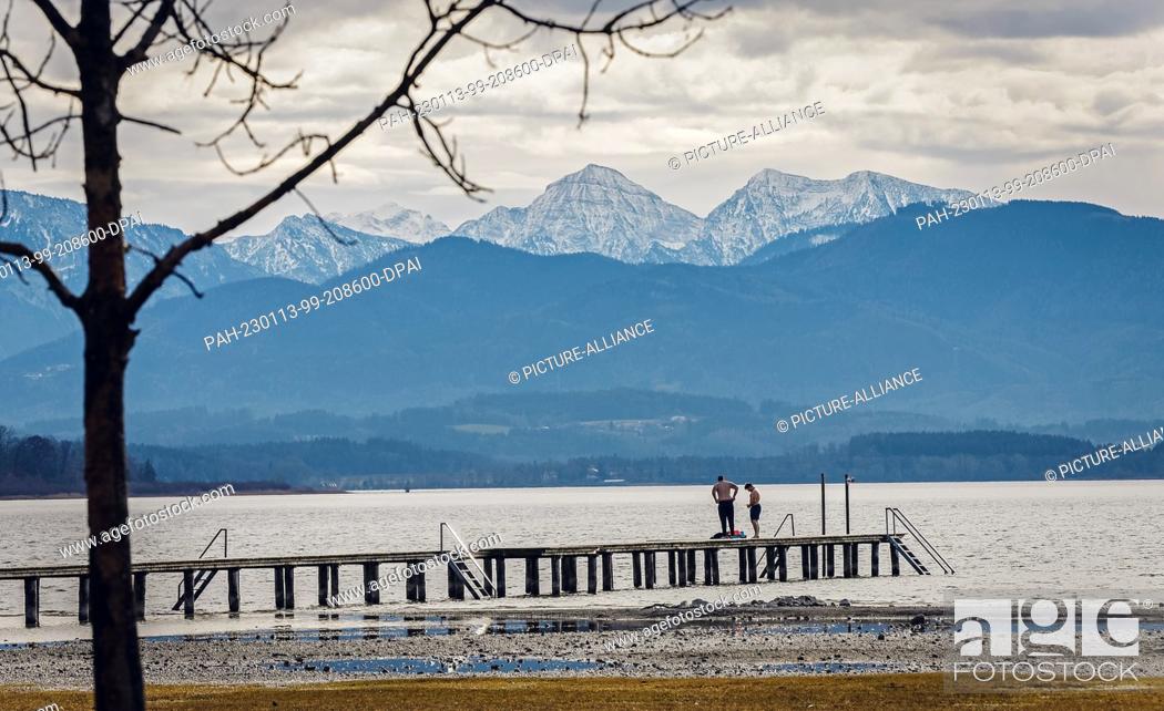 Imagen: 13 January 2023, Bavaria, Seebruck: Two men prepare for a swim in Lake Chiemsee in spring-like temperatures against the almost snow-free backdrop of the.