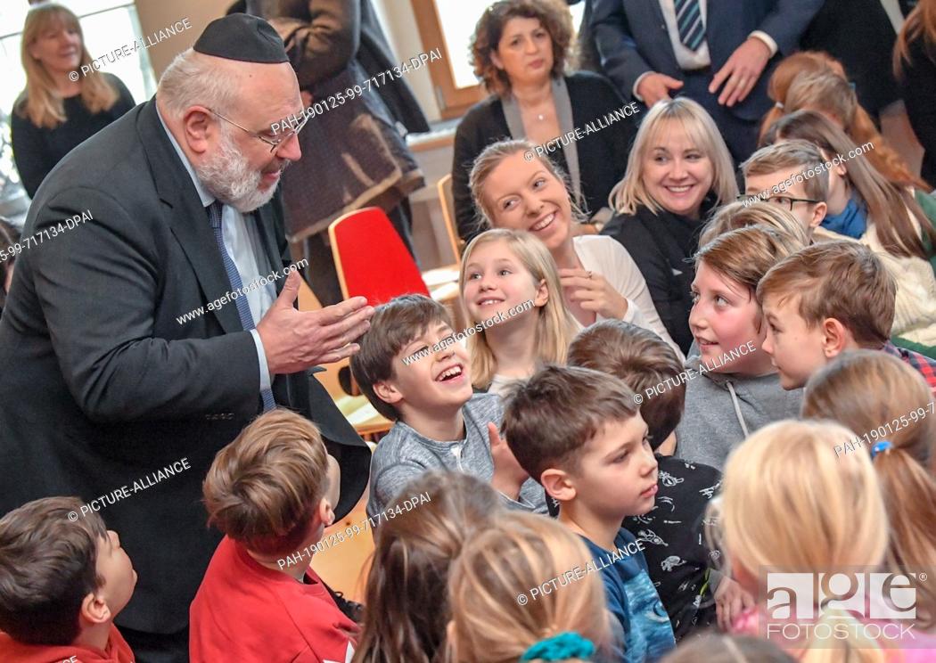 Stock Photo: 25 January 2019, Brandenburg, Cottbus: Walter Rothschild, Rabbi, speaks with children of the ""Moving Primary School"" before the ceremonial inauguration of the.