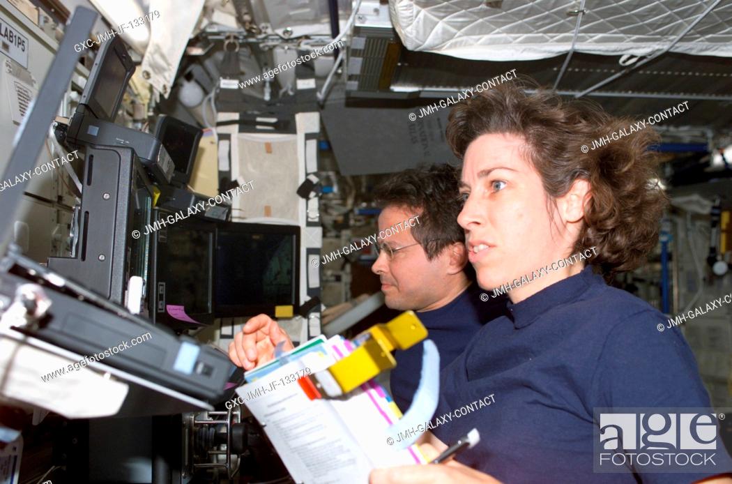 Stock Photo: Astronauts Ellen Ochoa (foreground), STS-110 mission specialist, and Daniel W. Bursch, Expedition Four flight engineer, work the controls of the Canadarm2 in.