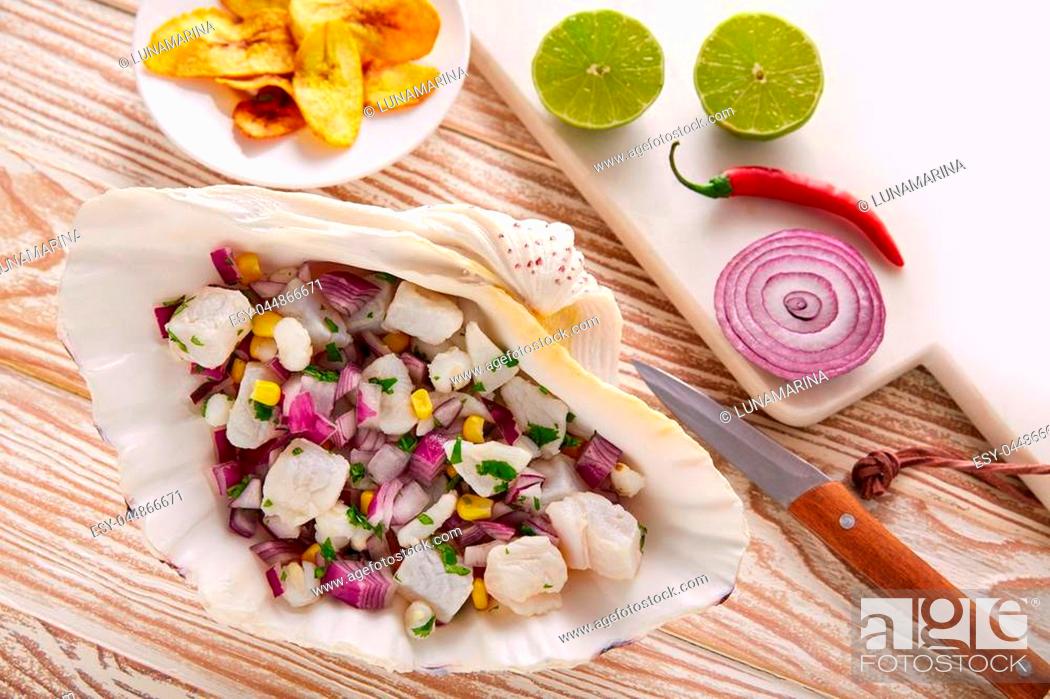 Stock Photo: Ceviche peruvian recipe with fried banana and ingredients on wooden table.