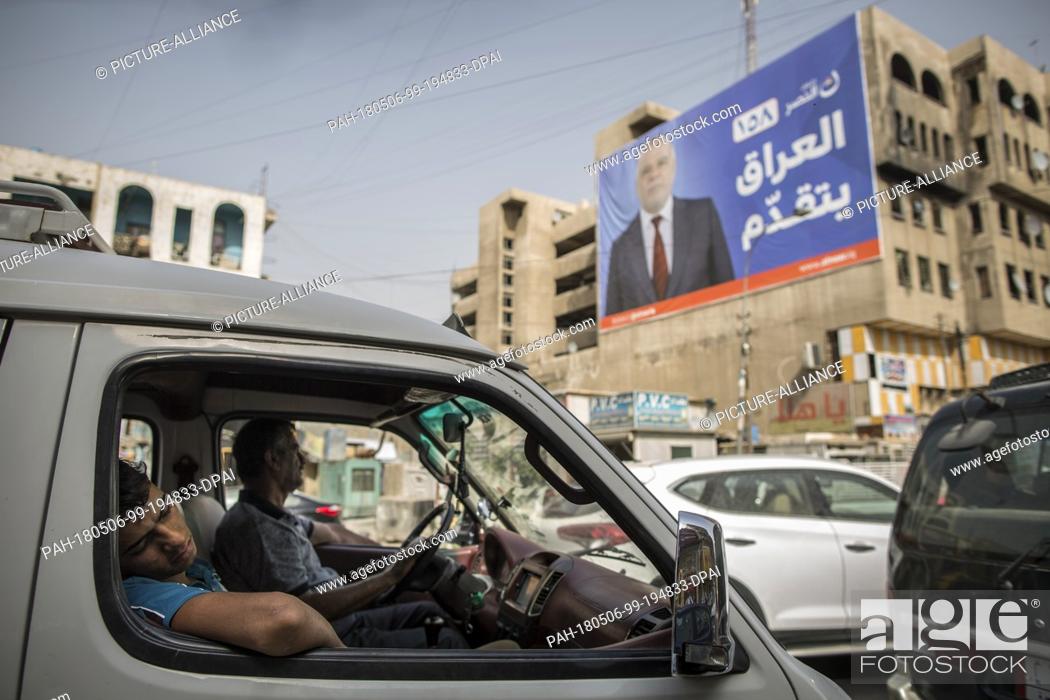 Stock Photo: A picture made available on 07 May 2018 shows a man sleeping in a car backdropped by a campaign poster of Iraqi Prime Minister Haider al-Abadi in Baghdad, Iraq.