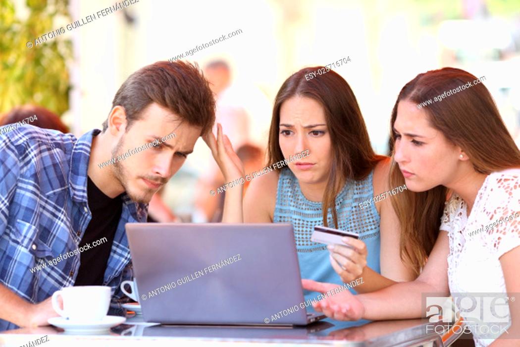 Stock Photo: Three shopper friends buying online with credit card finance problems in a coffee shop.