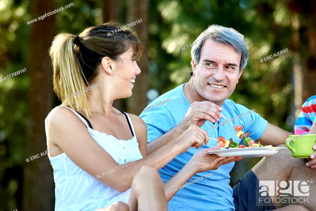 Stock Photo: Family having food during picnic.