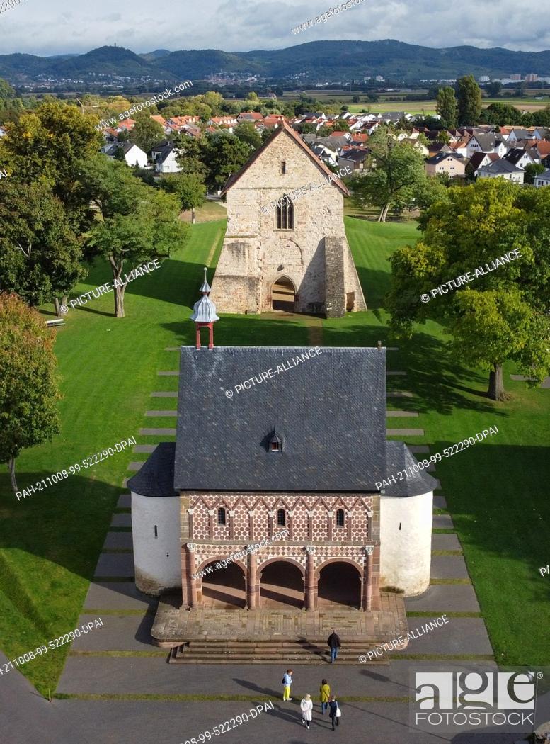 Stock Photo: 29 September 2021, Hessen, Lorsch: The so-called Gate Hall or King's Hall (front) with its world-famous colourful sandstone façade rises in front of a park-like.
