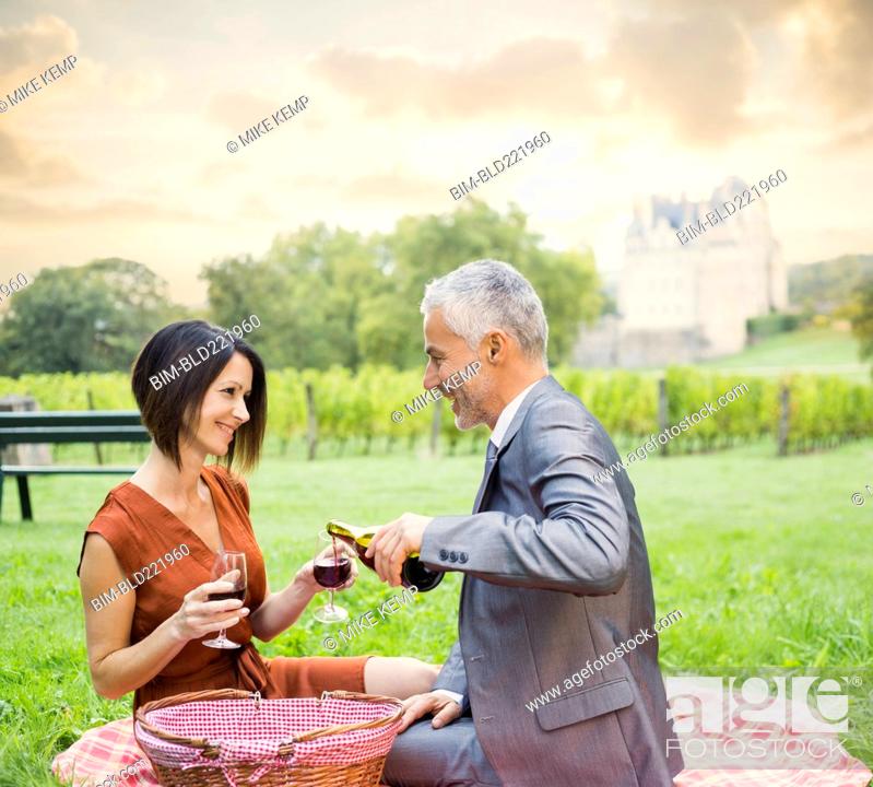 Stock Photo: Caucasian couple enjoying wine at picnic.