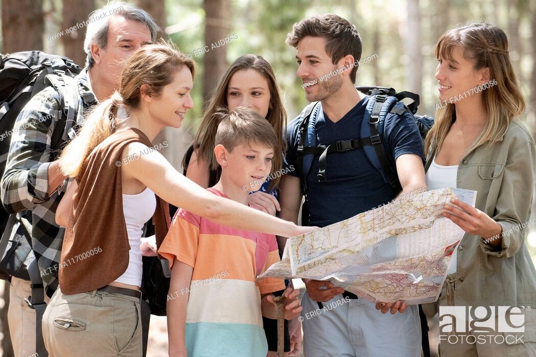 Stock Photo: Family reading a map while standing in forest.