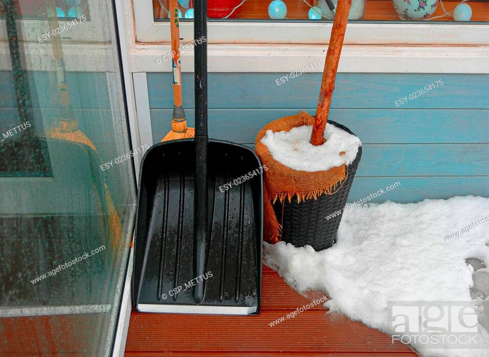 Stock Photo: Black snow shovel standing in the snow leaning wall.