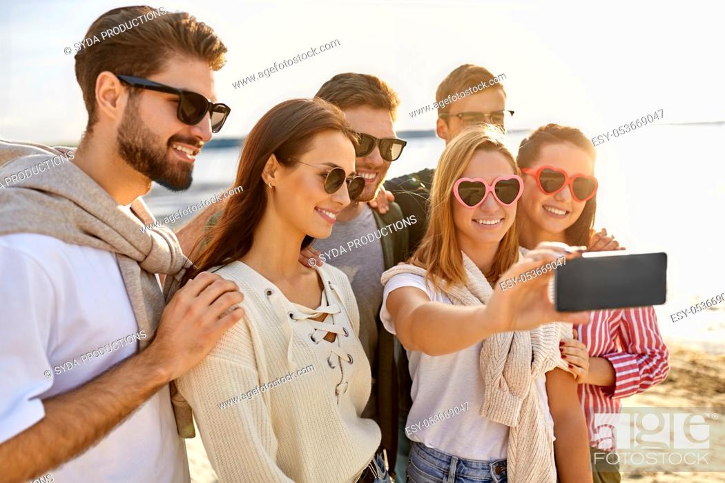 Stock Photo: happy friends taking selfie on summer beach.