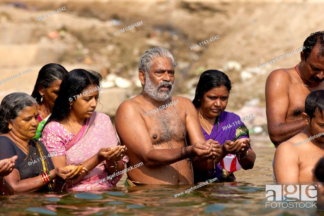 Stock Photo: Indian Hindu men and women bathing and praying in the River Ganges by Kshameshwar Ghat in holy city of Varanasi, India.