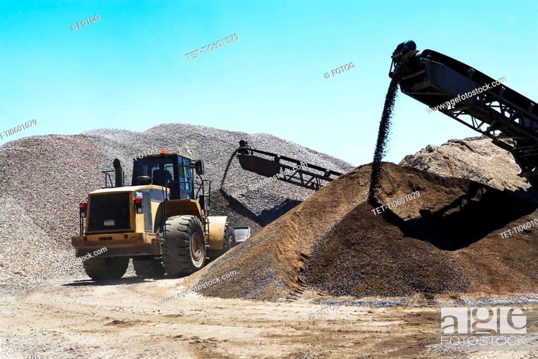 Stock Photo: Bucket loader moving pile of gravel.