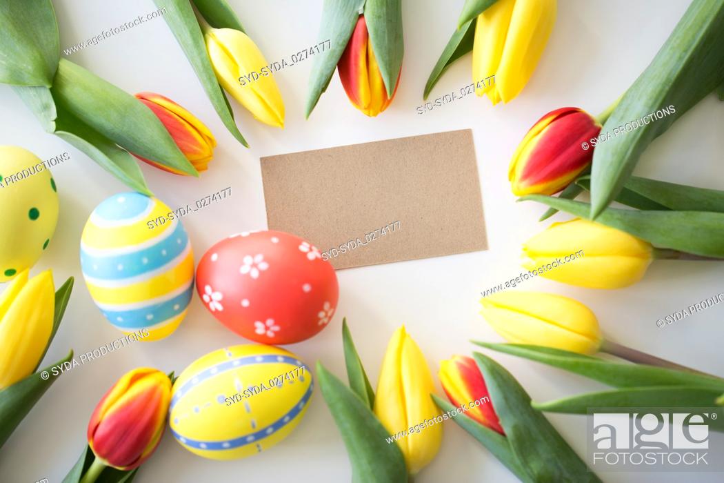Imagen: close up of colored easter eggs and tulip flowers.